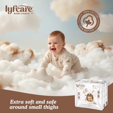 Baby sitting on fluffy clouds with Lyfcare baby pants packaging in the foreground